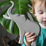 Child holding the Ostheimer trumpeting bull elephant wooden toy figure in their hand. 