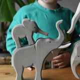 Ostheimer small elephant stacked on the back of the trumpeting bull elephant wooden toy figure.