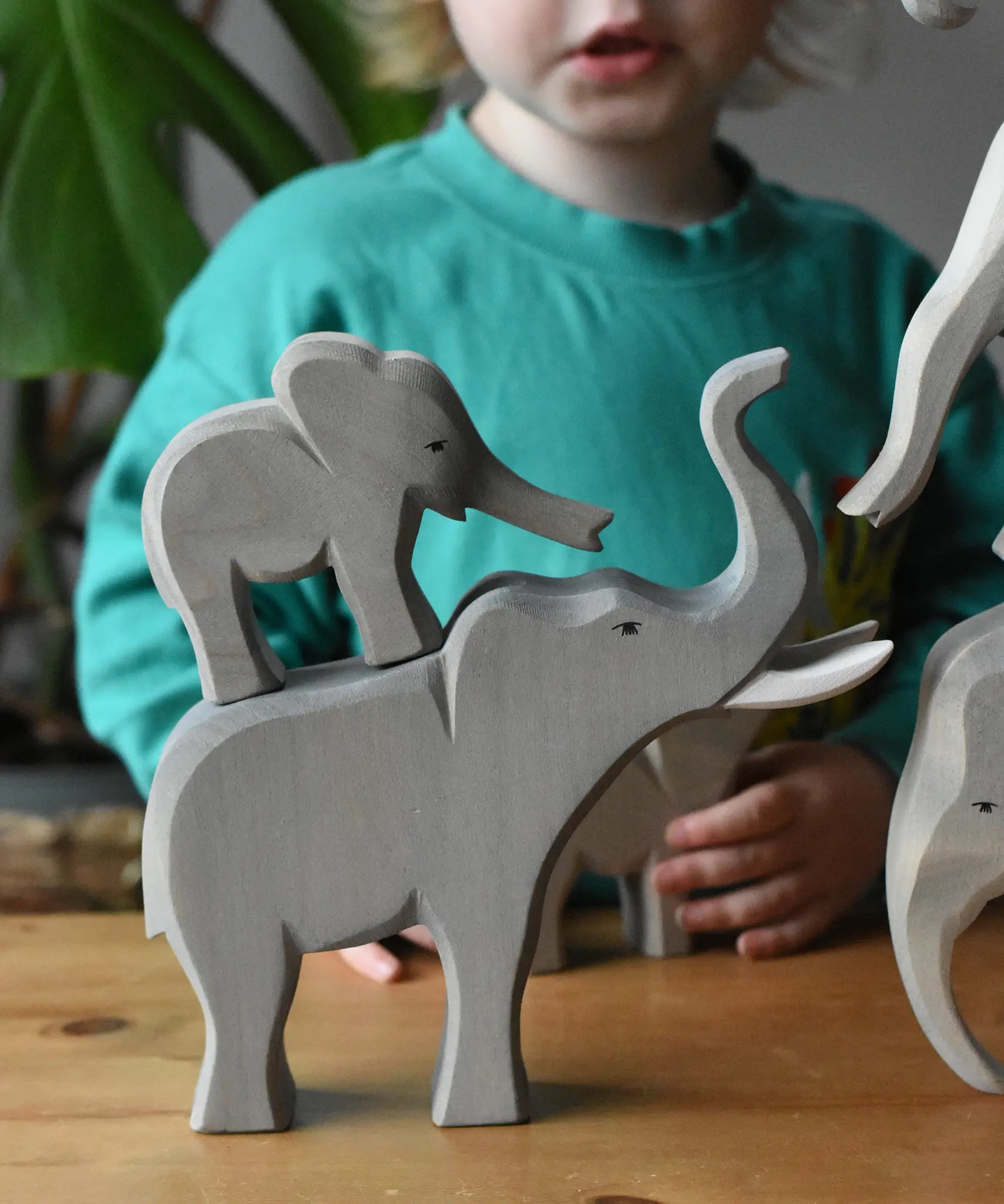 Ostheimer small elephant stacked on the back of the trumpeting bull elephant wooden toy figure.