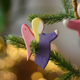 Ostheimer violet angel wooden handmade decoration placed on a Christmas tree branch. 