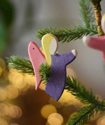 Ostheimer violet angel wooden handmade decoration placed on a Christmas tree branch. 