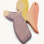 A wooden violet angel figure on a cream background