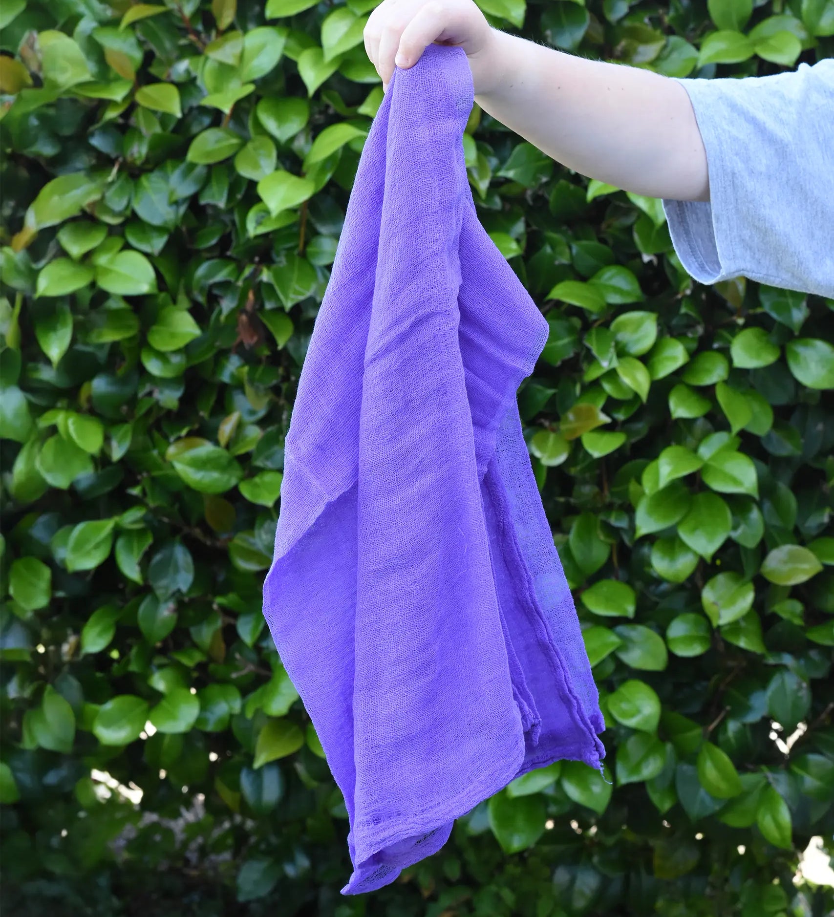 Ostheimer violet purple cotton play cloth in a child's hand.