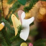 Ostheimer white angel wooden handmade decoration placed on a Christmas tree branch. 