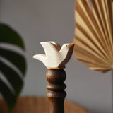 Ostheimer white dove wooden bird figure placed on a wooden stick. 