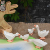 A gaggle of Ostheimer geese placed on and around the wooden pond scene piece/ The bird tree with an owl on the branch can be seen in the background.