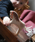 Child holding the Ostheimer wooden white horse for rider toy figure.