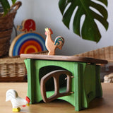 Ostheimer white rooster placed in front of a green hutch with a brown bremer rooster placed on the roof. 