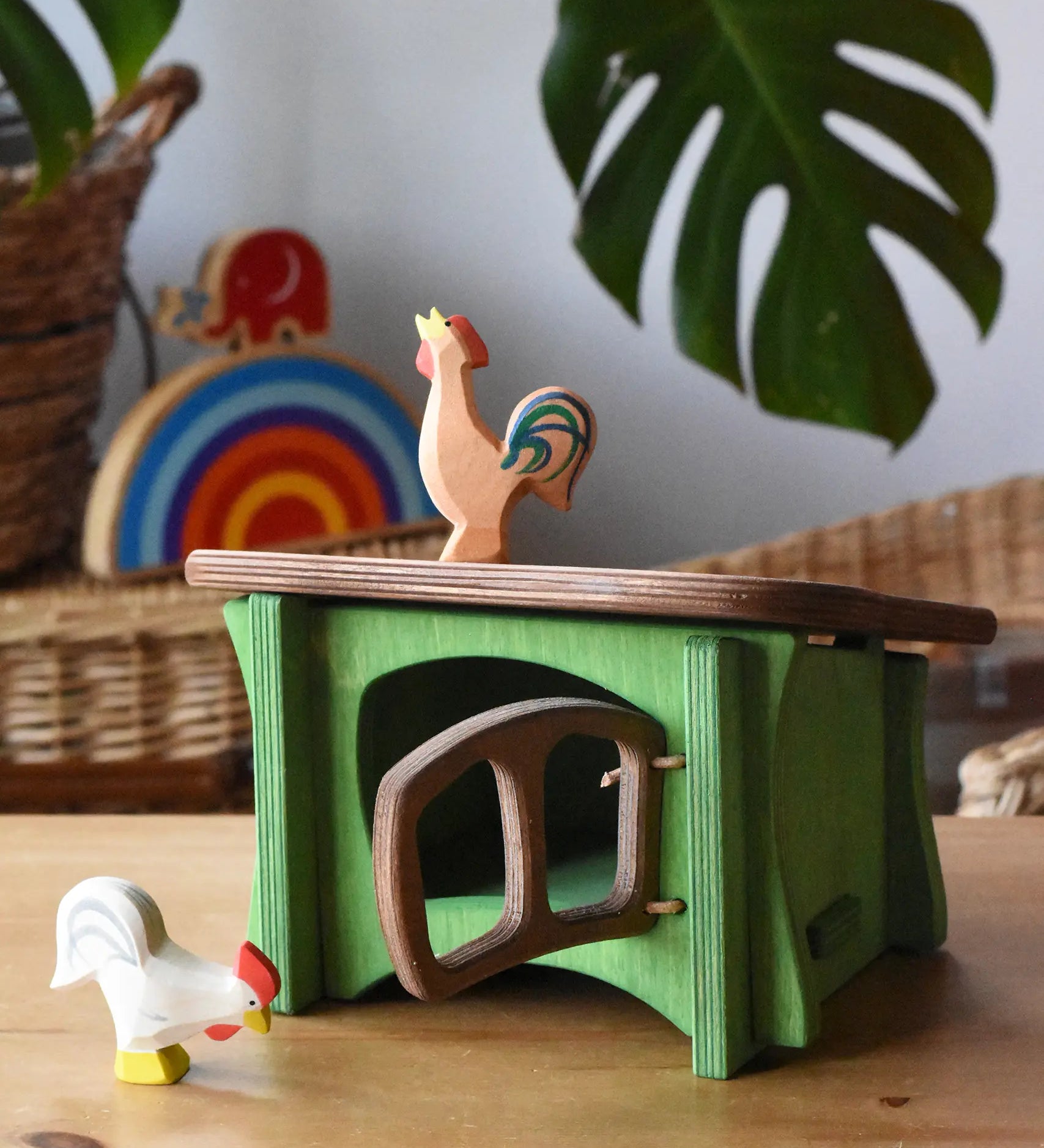 Ostheimer white rooster placed in front of a green hutch with a brown bremer rooster placed on the roof. 