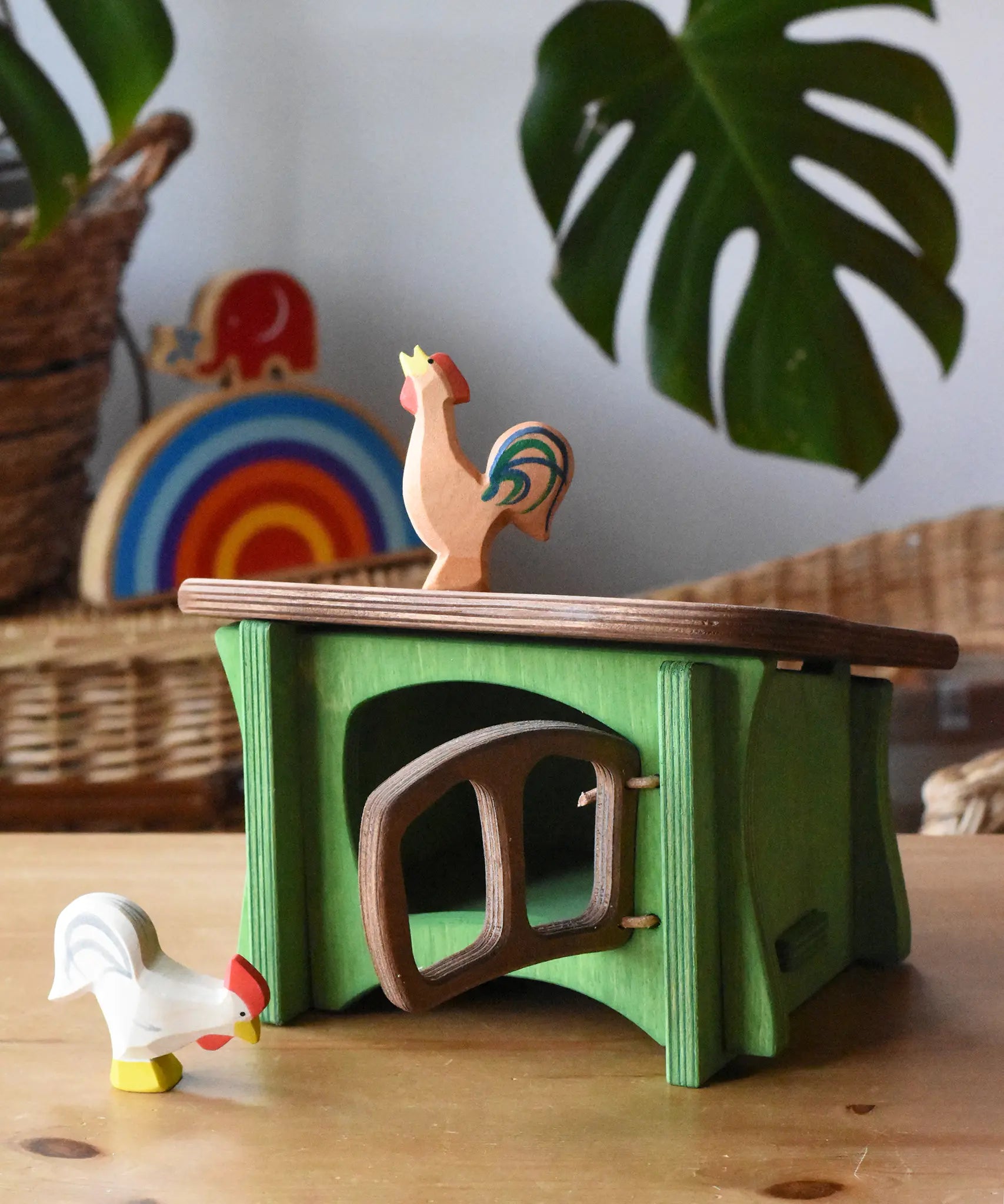 Ostheimer white rooster placed in front of a green hutch with a brown bremer rooster placed on the roof. 