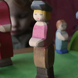 Ostheimer son wooden toy figure placed on a green meadow grass play base in a small world play scene. 