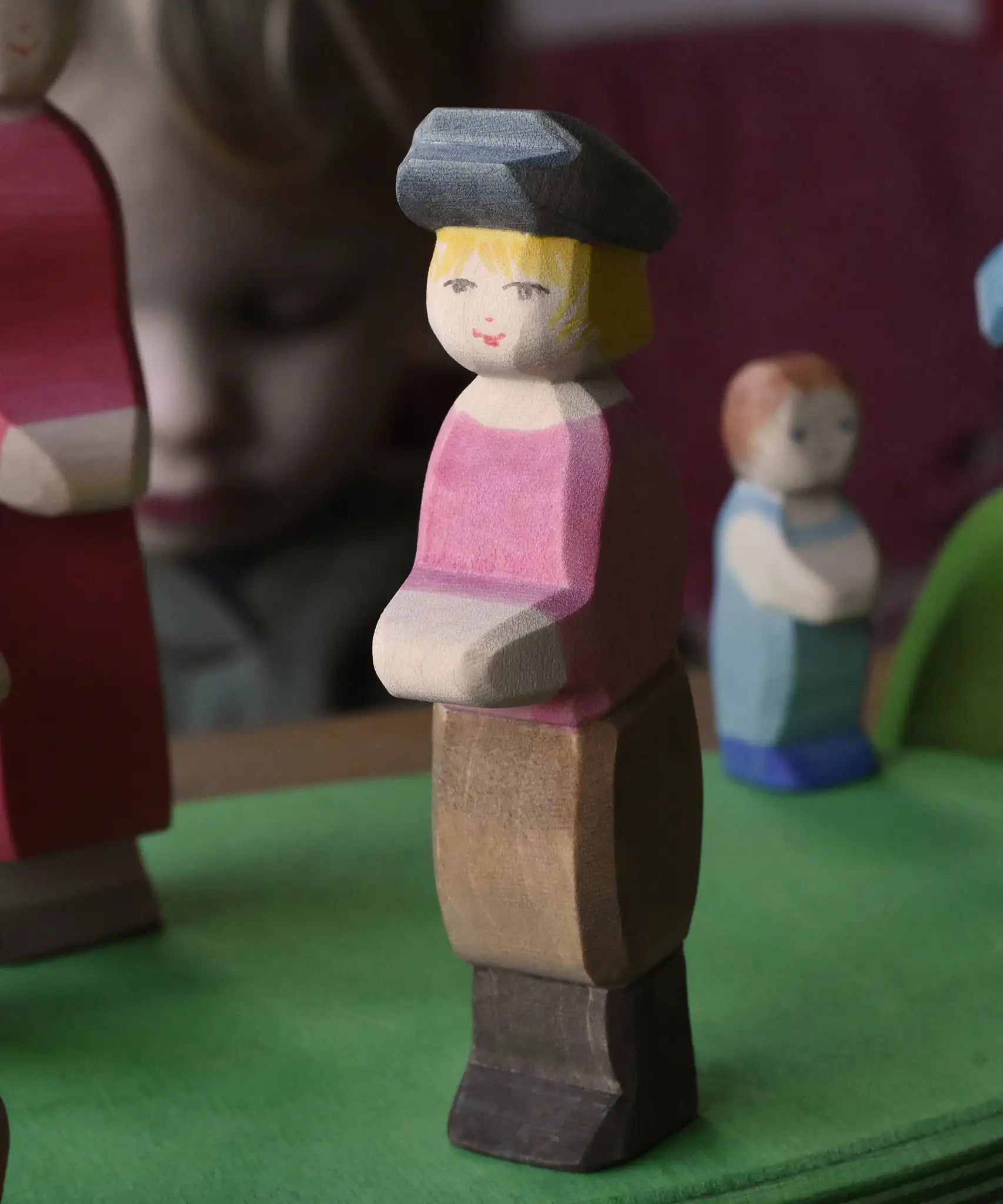 Ostheimer son wooden toy figure placed on a green meadow grass play base in a small world play scene. 
