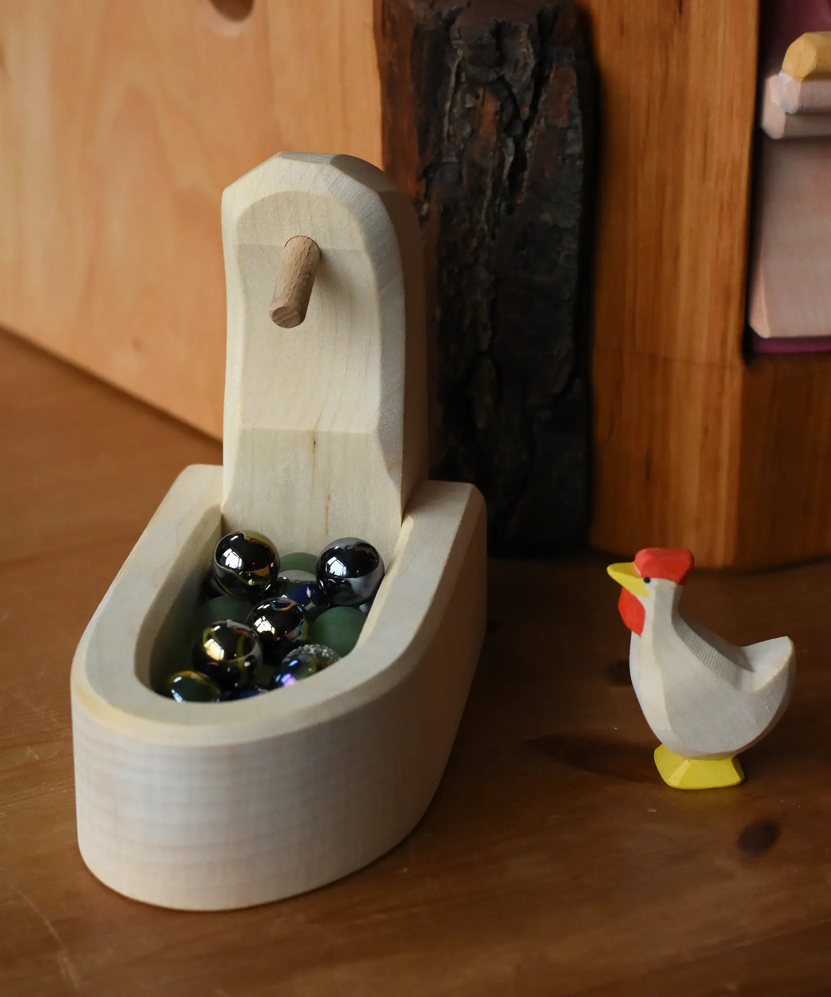 Ostheimer white hen with head up standing besides the white village well filled with Billes marbles.