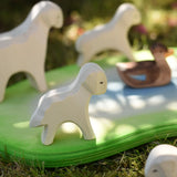 Ostheimer standing lamb wooden toy figure placed on the edge of a Ostheimer pond  in the Babipur garden.