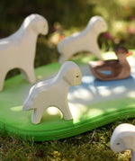 Ostheimer standing lamb wooden toy figure placed on the edge of a Ostheimer pond  in the Babipur garden.
