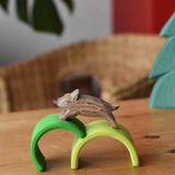 Ostheimer wild boar wooden toy figure placed on green arches from Grimm's mini rainbows. 