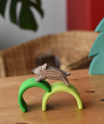 Ostheimer wild boar wooden toy figure placed on green arches from Grimm's mini rainbows. 