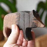 An Ostheimer wild boar sow wooden toy figure shown in an adult's hand for scale. 
