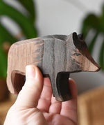 An Ostheimer wild boar sow wooden toy figure shown in an adult's hand for scale. 