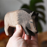 Ostheimer wild boar wooden toy figure in an adult's hand. 