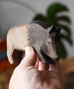 Ostheimer wild boar wooden toy figure in an adult's hand. 