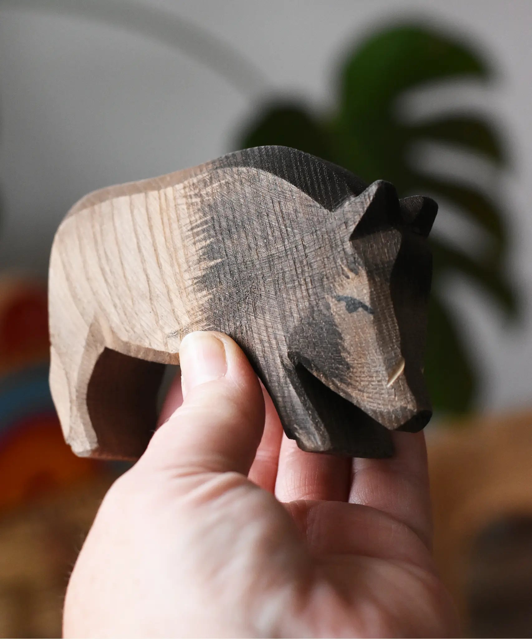 Ostheimer wild boar wooden toy figure in an adult's hand. 
