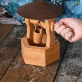 A child's hand winding up the bucket on the Ostheimer wooden wishing well toy. These wooden figures are part of a wide range of expertly hand crafted wooden toys here at Babipur. 