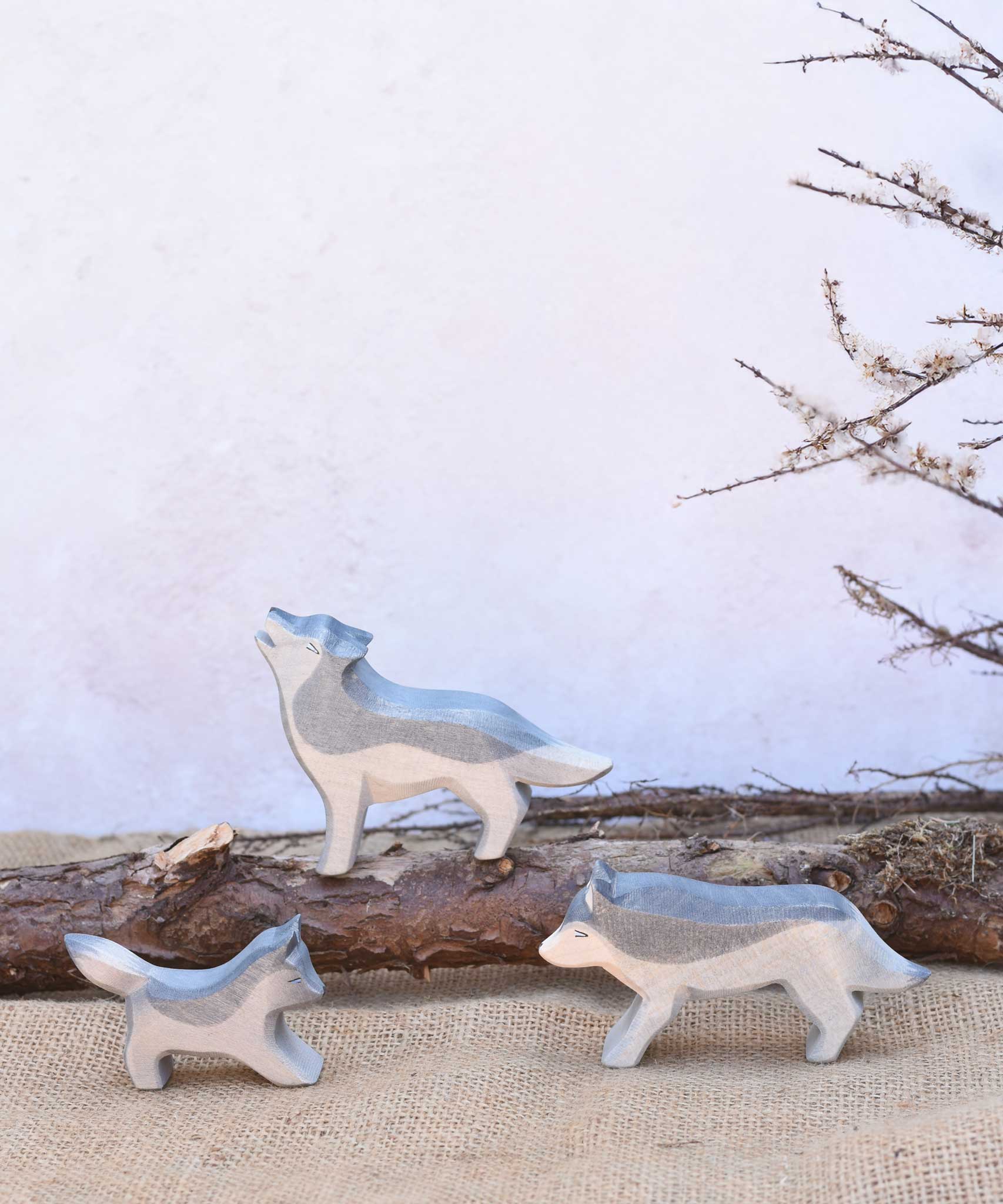 Three Ostheimer wolves wooden toy figures shown in a small world play set up. A full range of expertly crafted wooden toy figures and scenery are available here at Babipur.