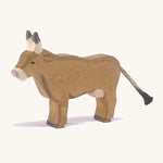 A wooden Ostheimer alp cow standing on a cream background.