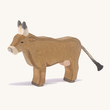 A wooden Ostheimer alp cow standing on a cream background.