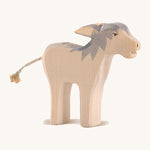 A wooden Ostheimer angry standing donkey on a cream background.