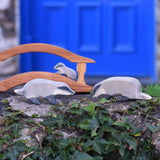 A group of badgers placed in a small world scene set up on a stone wall outdoors. A wide range of wooden animal figures and scenery pieces ca be found at Babipur. 