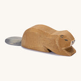 A wooden Ostheimer beaver lying down on a cream background.