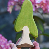 An Ostheimer Wooden Birch Tree Figure held in an adult's hand to show scale. Ostheimer wooden tree figures are perfect for setting scenes in small world and imaginative play. 