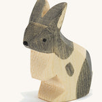 A wooden Ostheimer black and white standing rabbit figure on a cream background.