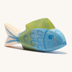 A blue wooden Ostheimer fish figure with green fins in a cream background.