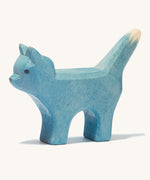 A blue wooden Ostheimer bremer standing cat figure on a cream background.