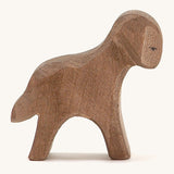 A brown wooden standing Ostheimer lamb figure on a cream background.