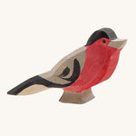 A wooden Ostheimer bullfinch bird figure on a cream background