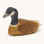 A wooden swimming Ostheimer Canadian goose on a cream background.