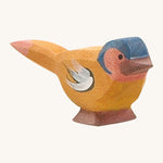 A wooden Ostheimer chaffinch bird figure on a cream background.