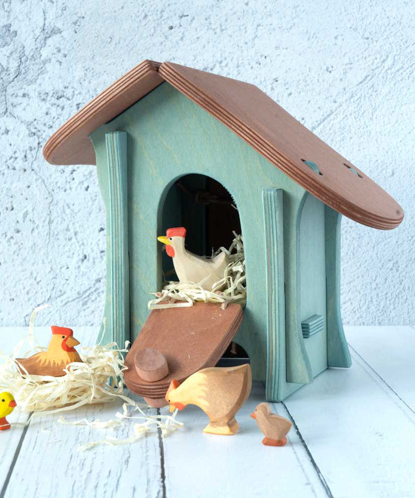 A wooden Ostheimer chicken house with Ostheimer chickens and hens outside