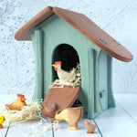 A wooden Ostheimer chicken house with Ostheimer chickens and hens outside