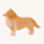 A wooden Ostheimer collie dog figure on a cream background.