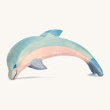 A wooden Ostheimer diving dolphin figure on a cream background.