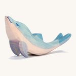 A wooden Ostheimer dolphin figure with its head held high on a cream background.