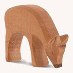 A wooden Ostheimer red deer eating figure on a cream background.