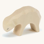 A white wooden eating sheep Ostheimer figure on a cream background.