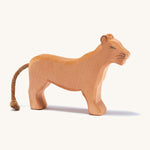 A wooden female Ostheimer lion figure on a cream background.