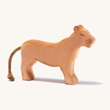 A wooden female Ostheimer lion figure on a cream background.